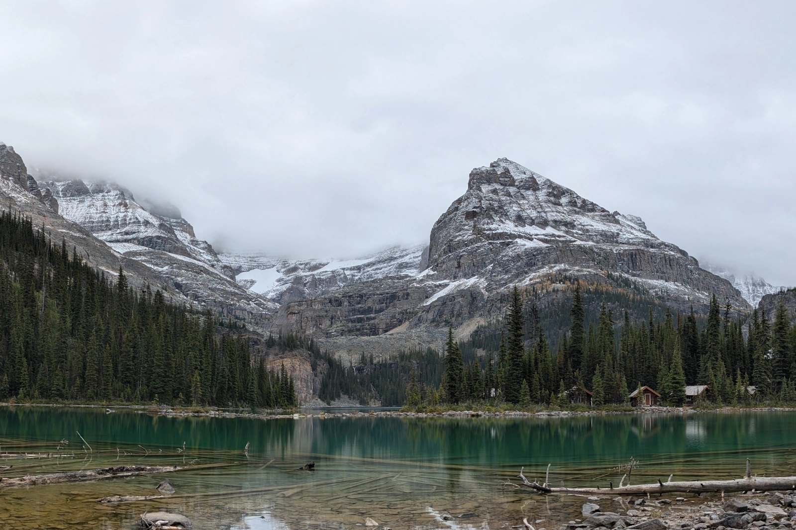 The turquoise waters and shoreline timber of Lake O'Hara under heavy autumn cloud cover, viewed before descending back to the valley floor.