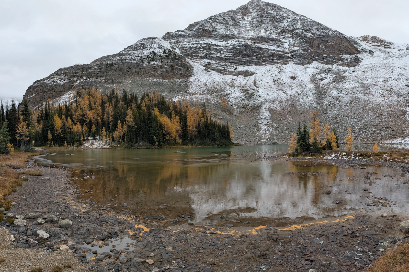 Lake Schaffer offers a quiet intermediate basin below Mount Schaffer, framed by stands of golden larches reflecting off glassy shallows.