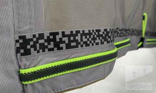 The hem has a dual adjustment and a rubberized band to help the jacket connect with the pants and prevent it from riding up and allowing snow inside.